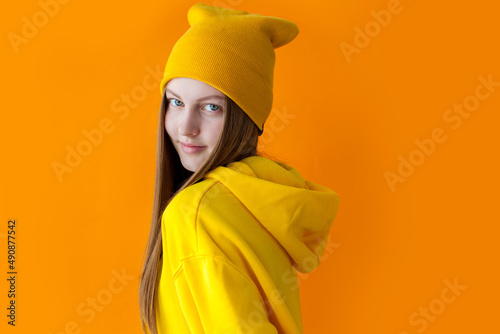 Young teen girl wearing yellow hoodie and hat, Hipster © Tatyana Gladskih