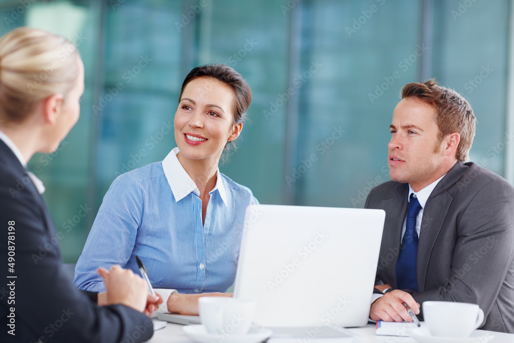 Sharing corporate suggestions with each other. Three business associates working together during a meeting. Sharing corporate suggestions with each other. Three business associates working together during a meeting.