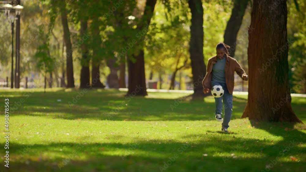 Happy father playing football in sunny park alone. Smiling player having fun. Happy father playing football in sunny park alone. Smiling player having fun.