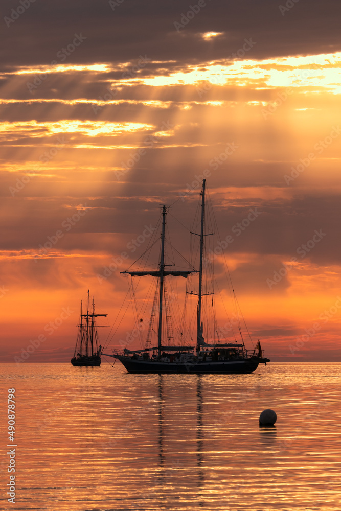 Silhouette of sailing vessel with dramatic sky.