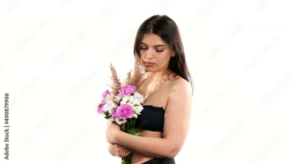Young lady standing with her back to the camera then she turns arround with bouquet of flowers covering her naked breast. Young lady standing with her back to the camera then she turns arround with bouquet of flowers covering her naked breast.