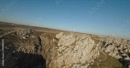 fpv drone over sea and cliffs at sunset