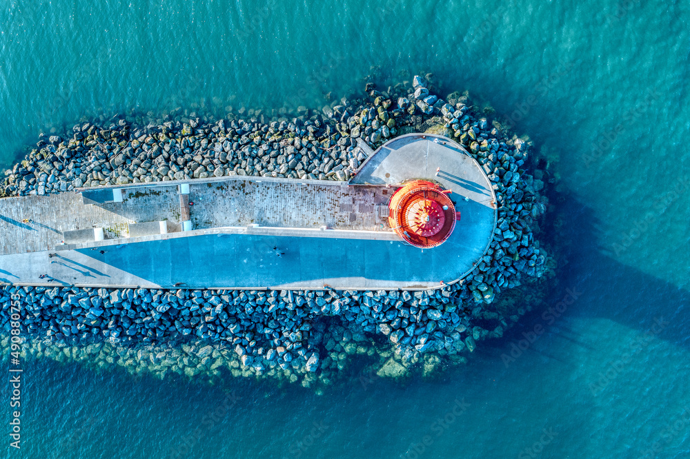 Aerial view of Poolbeg Lighthouse the famous red landmark in Dublin Harbor Ireland seen by drone at sunset