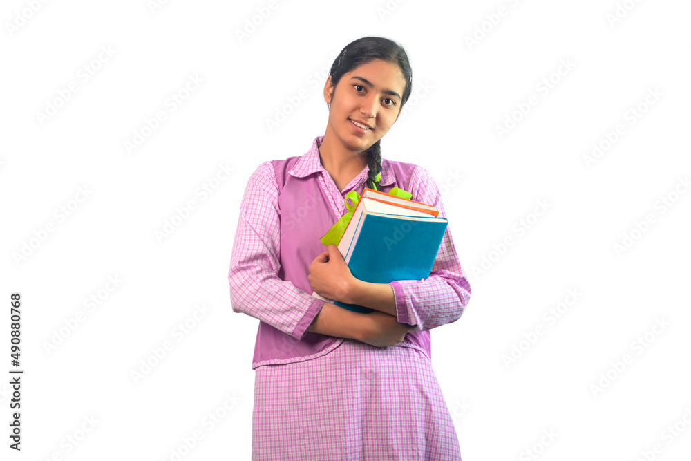 Happy Teenage schoolgirl looking at the camera smiling and holding a book