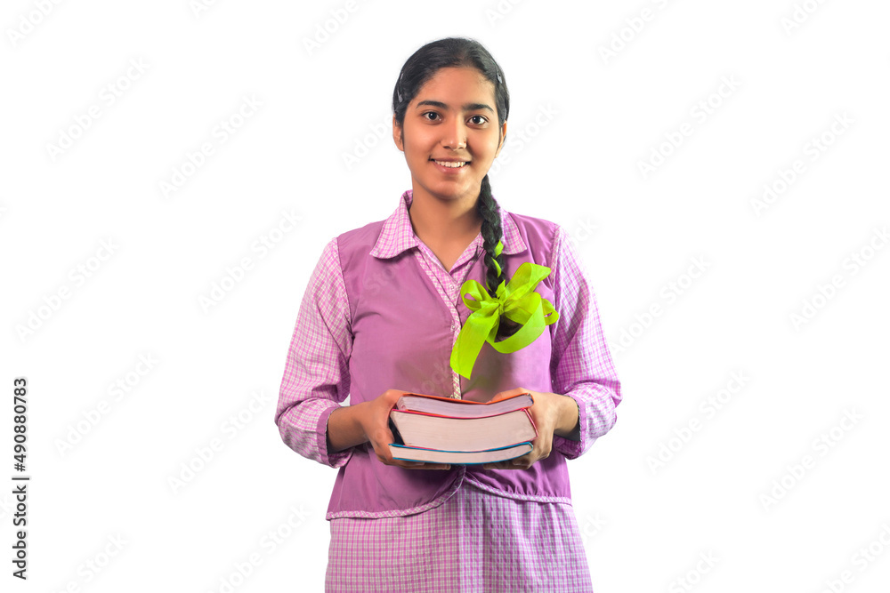 Happy Teenage schoolgirl looking at the camera smiling and holding a book Happy Teenage schoolgirl looking at the camera smiling and holding a book
