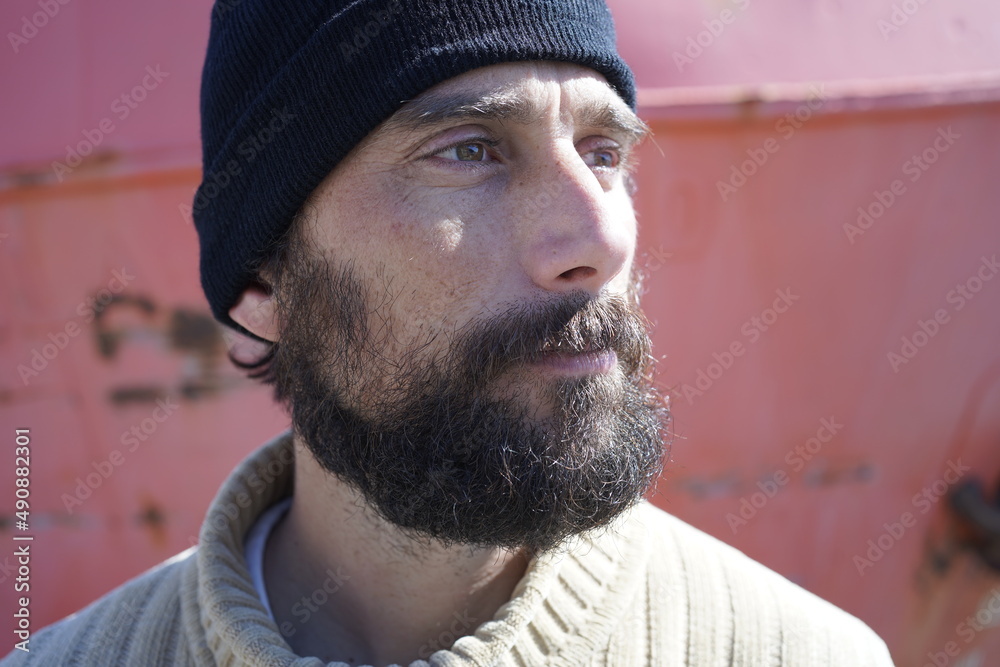 © javiemebravo - close-up portrait of a bearded sailor man with a calm expression looking at the horizon, the warm sun shining on his face