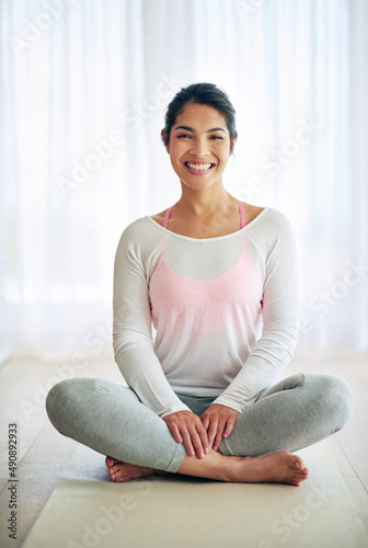 Home is where my mat is. Portrait of an attractive young woman doing yoga at home.