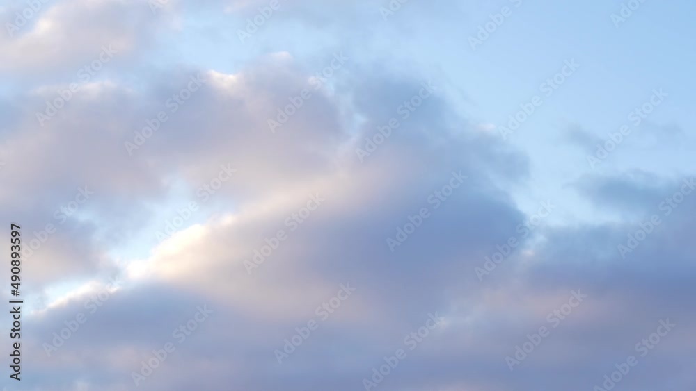 Beautiful sky with clouds background, puffy fluffy beautiful pink clouds on turquise sky time lapse. Sun ray at sunshine day before sunset in the evening