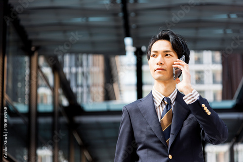 オフィス街でスマートフォンを使うビジネスマン