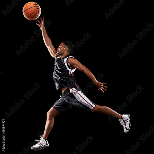 Taking his game up a level. Studio shot of a basketball player against a black background. © Duncan M/peopleimages.com