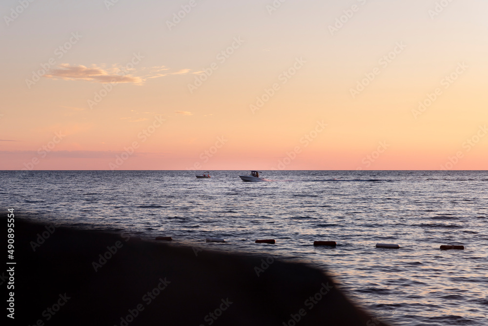 Boat sailing at sunset at sea Boat sailing at sunset at sea