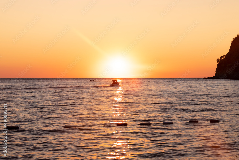Boat sailing at sea at amazing sunset