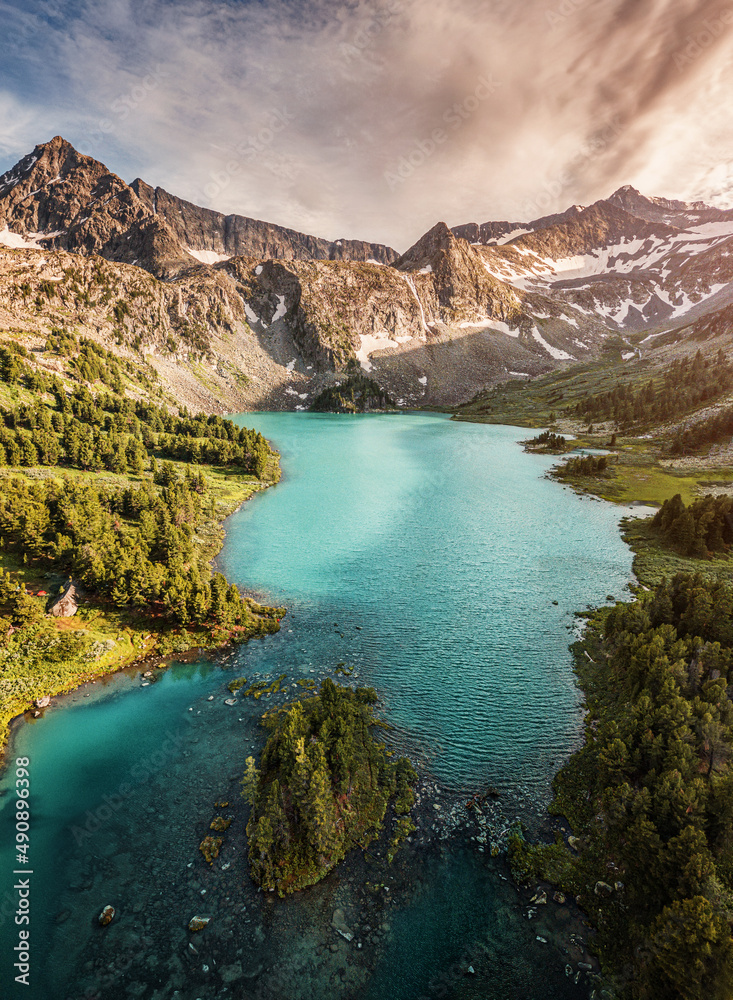 Vertical panorama aerial view of a natural wonder - turquoise and emerald lake in the middle of mountain peaks with glaciers. Pure and untouched nature
