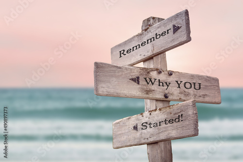Foto remember why you started text quote written on wooden signpost by the sea