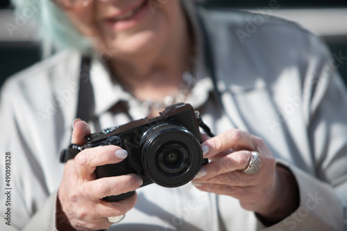 woman's hands holding a digital camera outdoors