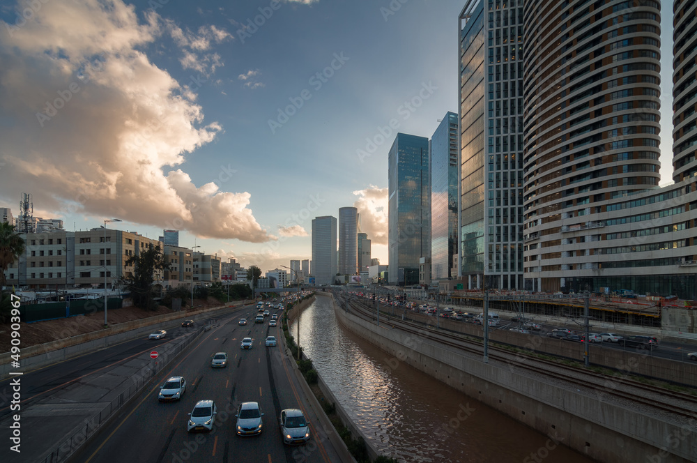 Tel Aviv city sunset. Modern glass skyscrapers and automobile Ayalon highway