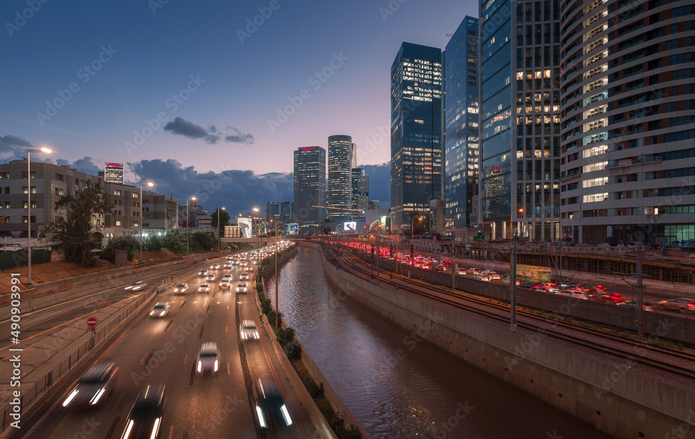 Tel Aviv city sunset. Modern glass skyscrapers and automobile Ayalon highway