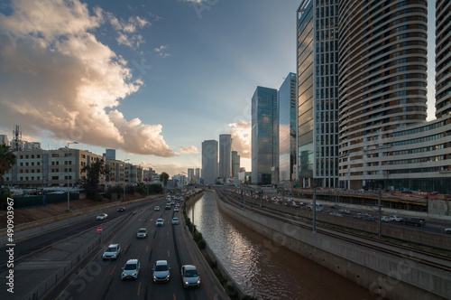 Tel Aviv city sunset. Modern glass skyscrapers and automobile Ayalon highway