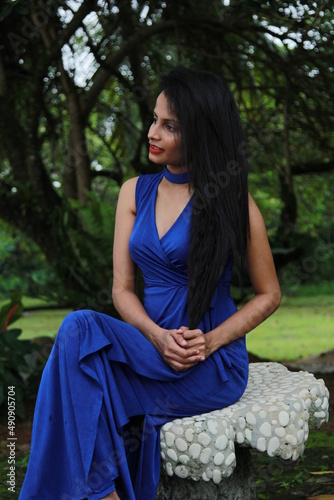 Beautiful girl in a long blue dress. A young woman of Asian descent with black hair