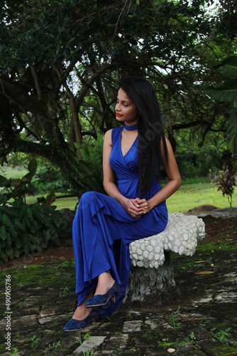 Beautiful girl in a long blue dress. A young woman of Asian descent with black hair