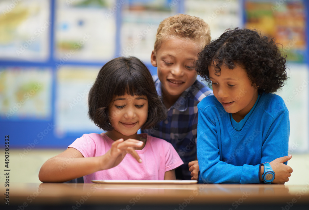 Tablet-assisted learning. Three school students working on a digital tablet in class. Tablet-assisted learning. Three school students working on a digital tablet in class.