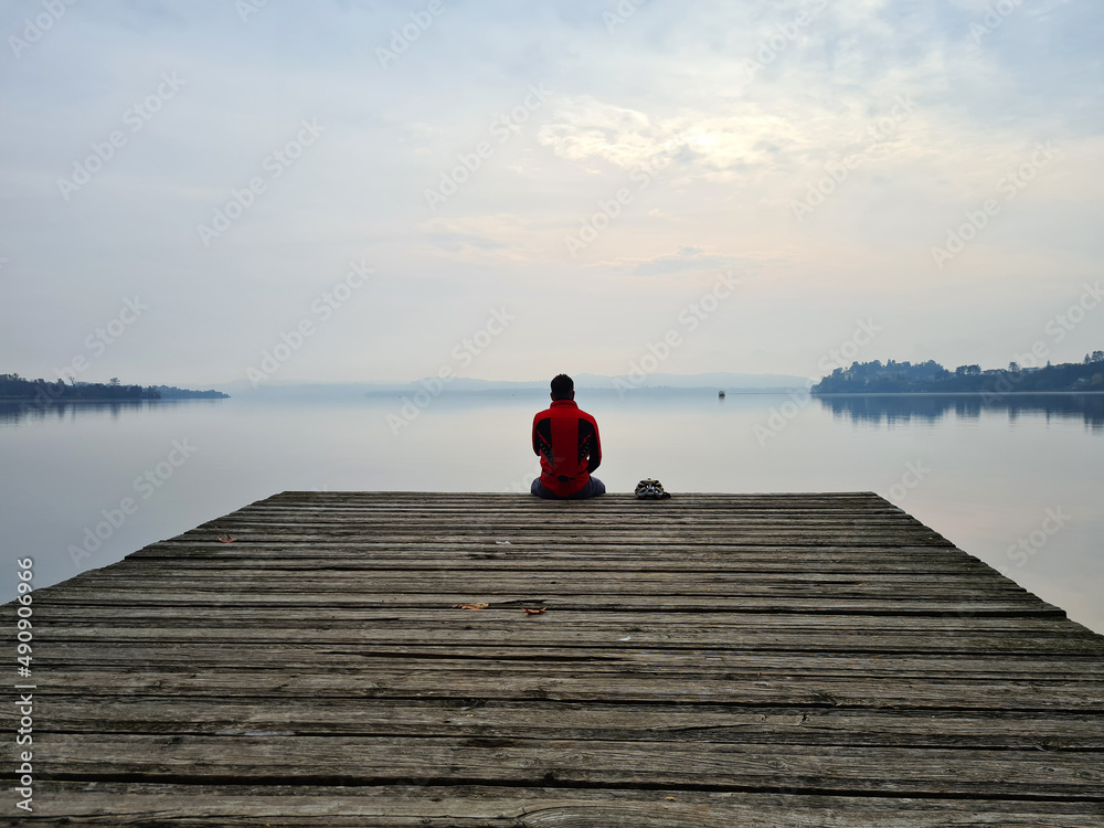 person sitting on a pier