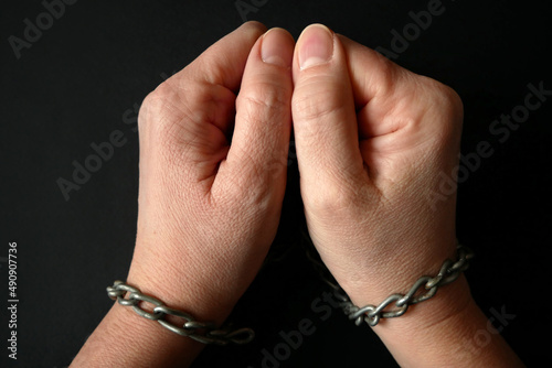 hands clenched into fists in handcuffs in the form of chains on a black background, the problem of slavery and violence concept, juneteenth Freedom Breaking Chains