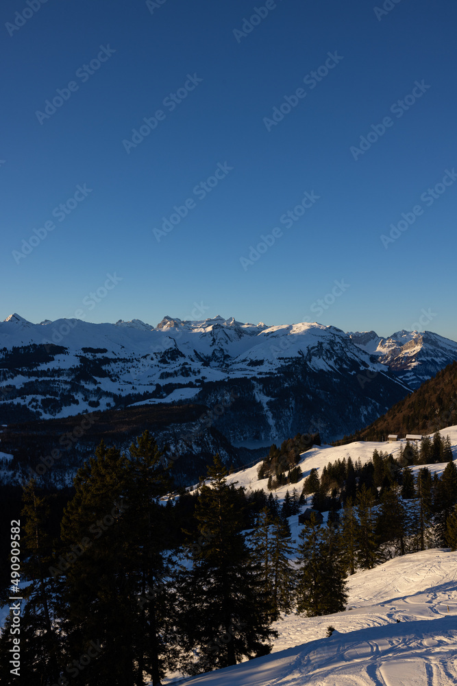 Super panorama of a Swiss mountain ridge that is illuminated by the sun at sunrise. Beautiful wintry and snowy landscape. what a view.