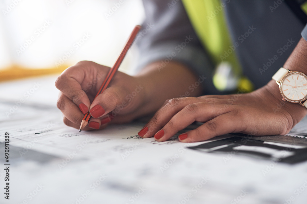 Planning ensures success. Cropped shot of an unrecognizable female construction worker looking over plans on site. Planning ensures success. Cropped shot of an unrecognizable female construction worker looking over plans on site.