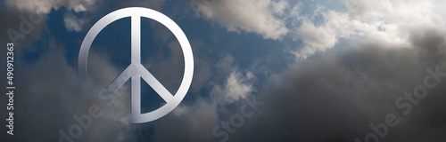 Photo The international symbol of peace emerging from dark clouds as sun shines on it