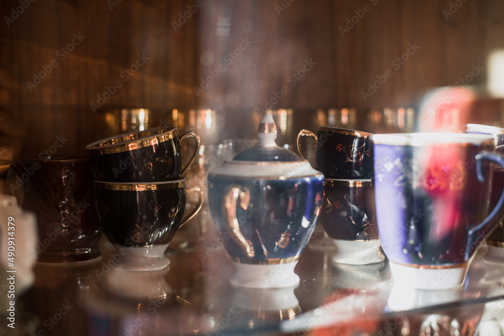 Antique old service. Old service in a sideboard at a summer cottage. collection of tea porcelain service, cobalt gilding, service behind the flow Antique old service. Old service in a sideboard at a summer cottage. collection of tea porcelain service, cobalt gilding, service behind the flow