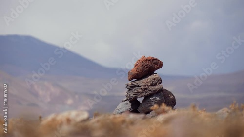 A Pile Of Stones Stacked In The Shape Of Cairn On A Background Of The Mountain photo