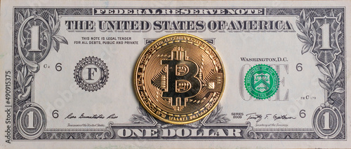 Gold coin bitcoin on the background of the american dollar