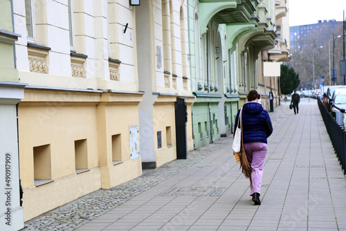Kobieta ze słuchawkami na głowie idzie chodnikiem we Wrocławiu. © Stanisław Błachowicz