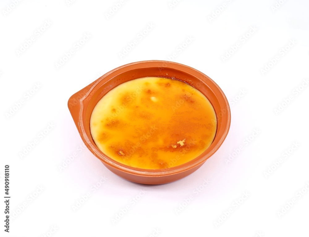Catalan cream in a terracotta bowl in white background. Catalan cream in a terracotta bowl in white background.