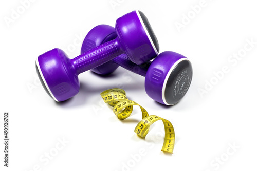 Dumbbells and measuring tape on white background