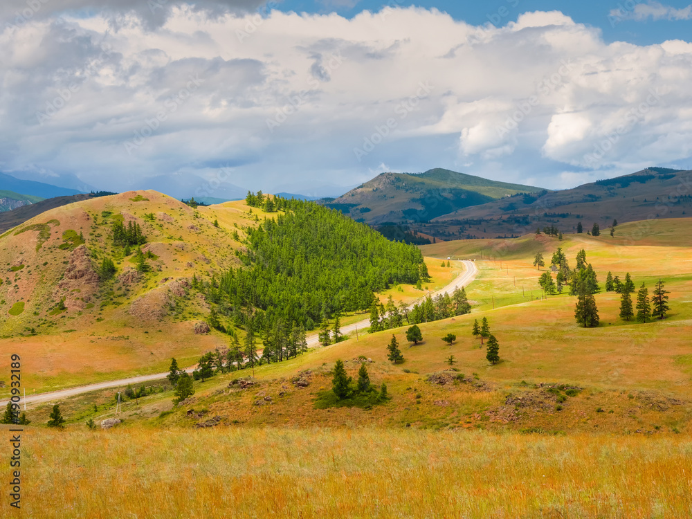 Naklejka premium Picturesque summer mountain landscape with road through the pass. Turn on the asphalt mountain highway. Chuysky tract and a view of the North Chuysky Mountain range in the Altai, Siberia, Russia.