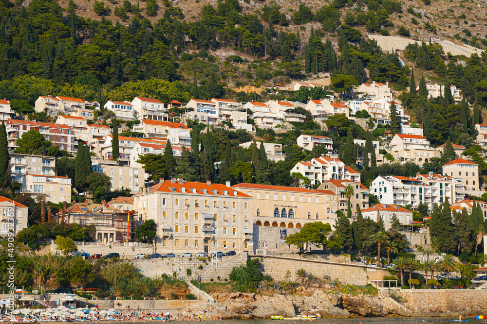Modern buildings and villas on the sea coast, on mountain background. Dubrovnik city, Croatia.