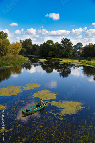 Fisherman on a wooden boat on the river photo