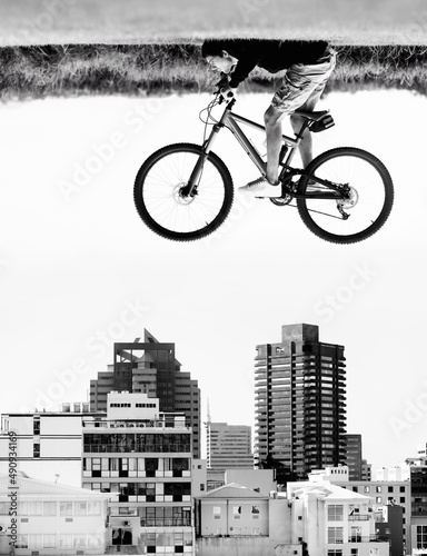 The sky is the limit. A man on a bicycle hovers in the air over the rooftops of a city - perception. © Dominique Baptie/peopleimages.com