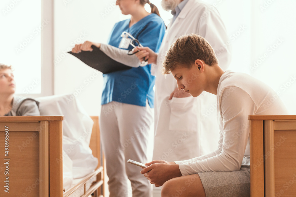Fototapeta premium Intern and doctor writing something on legal pad during hospital visit