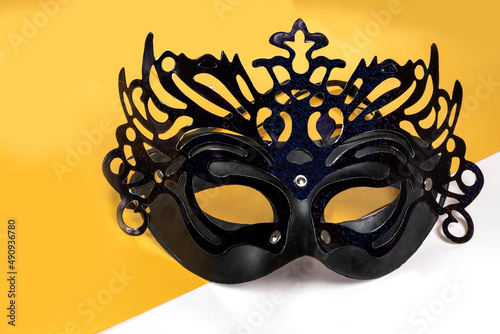Happy Purim carnival mask on yellow-white background.