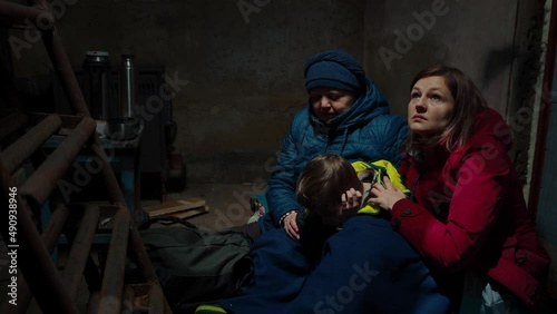 A scared family two women and a child hiding from danger in the cellar
