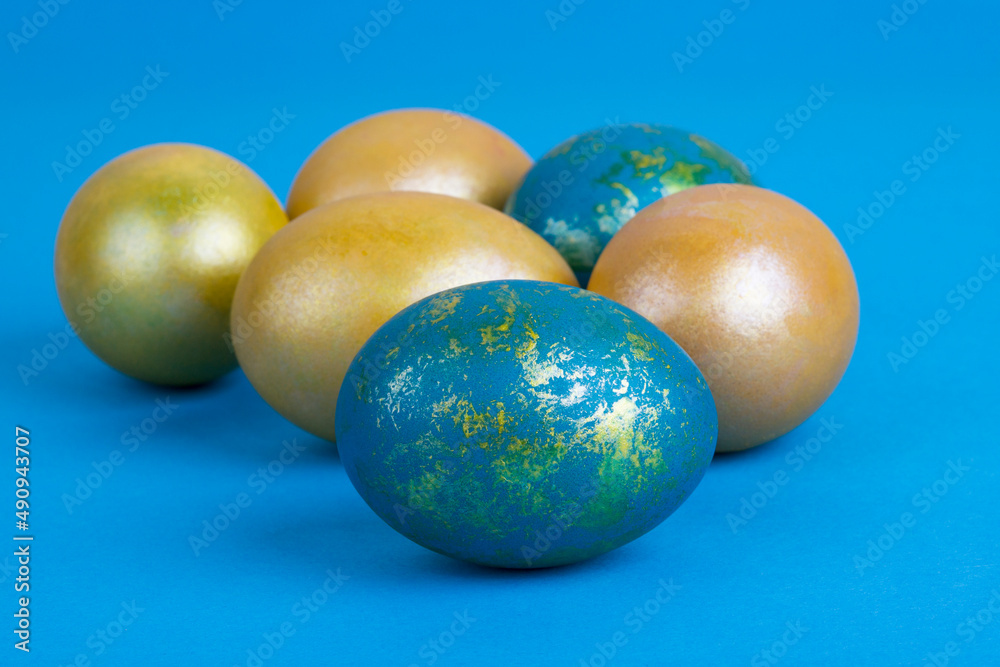 Golden Easter eggs on a blue background. Easter background Golden Easter eggs on a blue background. Easter background