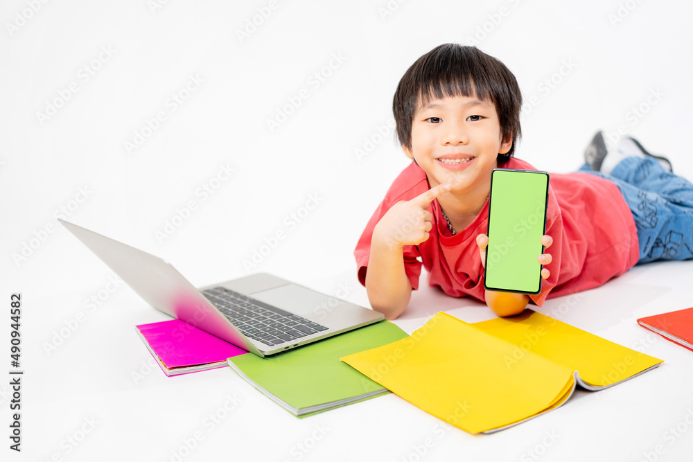 Portrait of Happy asian boy holding a phone in his hands with a green screen on floor with with laptop and books isolated on white background with copy space, Education and learning with technology Portrait of Happy asian boy holding a phone in his hands with a green screen on floor with with laptop and books isolated on white background with copy space, Education and learning with technology