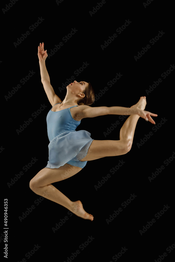 girl-dancer in a jump on a black background
