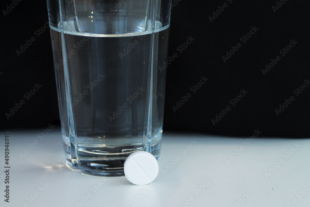 Glass of water and an effervescent tablet or pain killer pill Glass of water and an effervescent tablet or pain killer pill