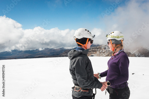 Couple enjoys snowy glacier summit together all geared up, obviously in love