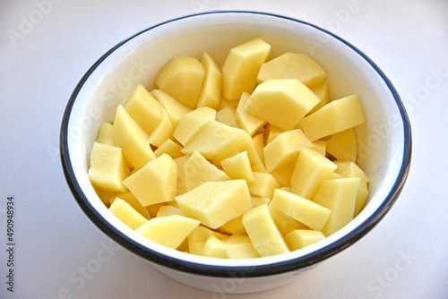 Peeled potatoes in strips in a white saucepan