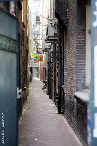 Narrow street between two houses in Amsterdam, Netherlands. © MNStudio